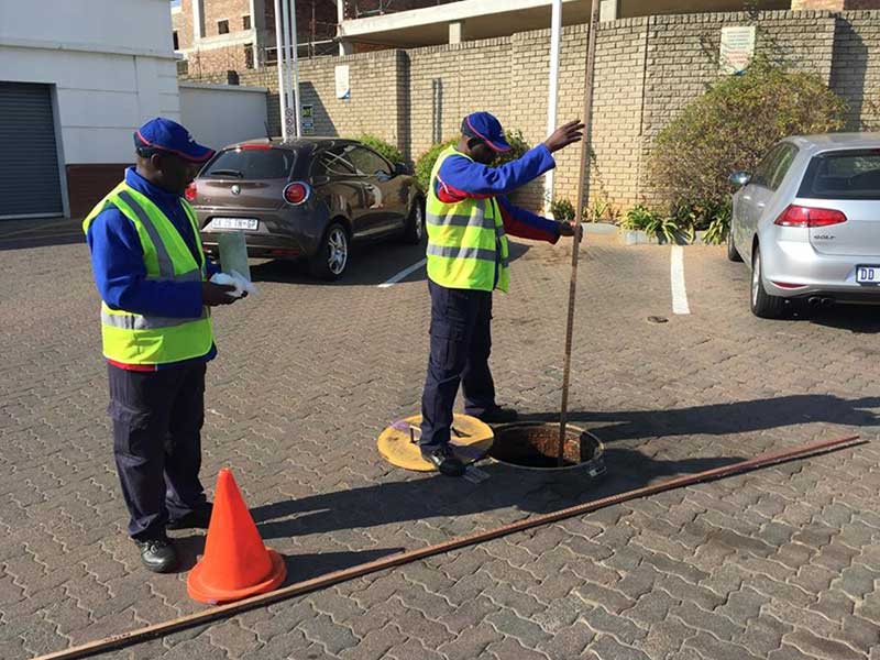 workers using a dipstick to measure fuel levels